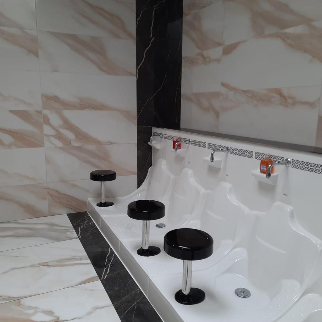 Row of urinals with stools.